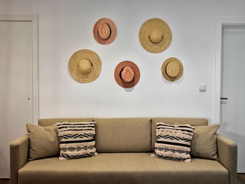 埃尔瓦斯The Bastion Elvas Apartments的客厅配有沙发和挂在墙上的帽子