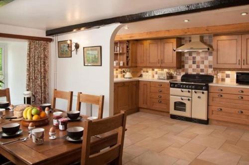 克里克豪厄尔Scenic Welsh Cottage in the Brecon Beacons的一间带木桌的厨房和一间餐厅