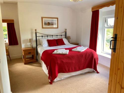 克里克豪厄尔Scenic Welsh Cottage in the Brecon Beacons的一间卧室配有一张带红色毯子的大床