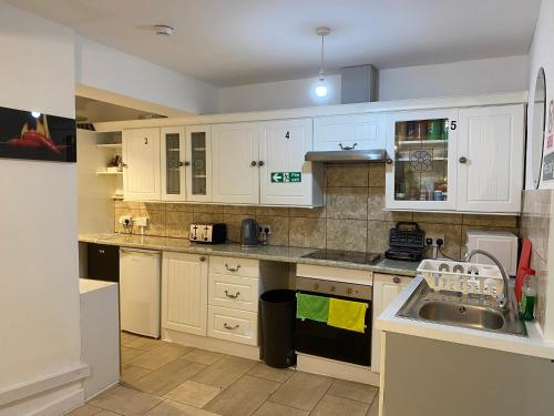 WykenCalm residential house的厨房配有白色橱柜和水槽