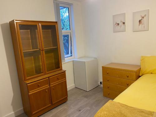 WykenCalm residential house的一间卧室设有大型木制橱柜和一张床