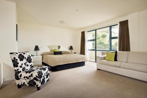 芒格努伊山海滨双塔度假酒店的一间卧室配有一张床、一把椅子和一张沙发