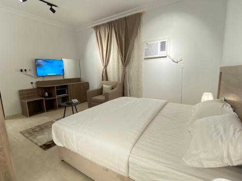 泰布克نايتس للوحدات المفروشة的卧室配有白色的床和电视。
