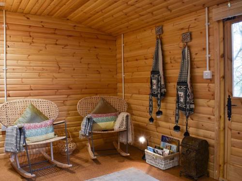 科尔切斯特Easthorpe Retreat的一间设有两把椅子和木墙的房间