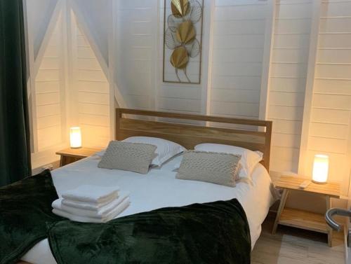 波尔兰特Le Jardin Zen的一张带两个枕头的床和毛巾