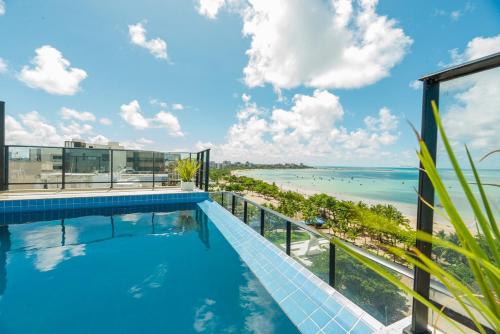马塞约Vistamar Hotel的一座海景建筑屋顶上的游泳池