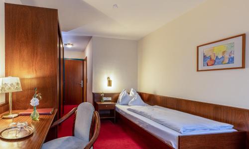 多恩比恩Hotel Katharinenhof STANDARD的一间卧室配有一张床、一张桌子和一把椅子