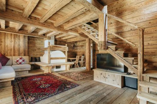 科尔蒂纳丹佩佐Luxury Cortina的小木屋客厅设有木制天花板和电视