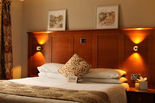 斯卡伯勒橡木轮宾馆的一间卧室配有一张带木制床头板的床