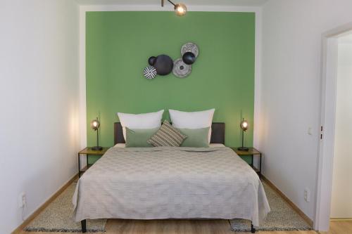 开姆尼茨Business-Apartment - Citynah, WLAN, Drucker, Netflix & Parken的一间卧室配有一张带绿色墙壁的床