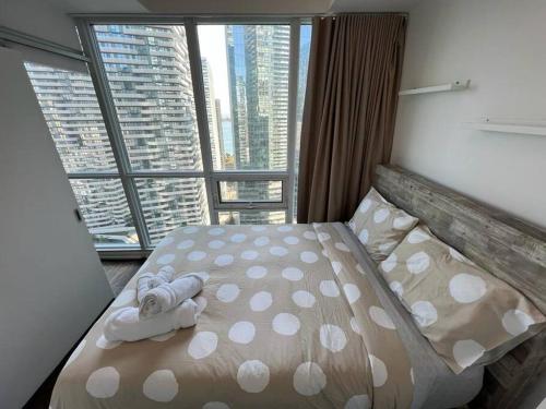 多伦多Centrally Located - Spacious 2-Bdrm Condo - Next to Scotiabank Arena的一张位于带大窗户的房间内的床铺