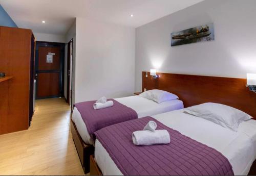 库鲁SAS CLP - La Marina的两张位于酒店客房的床,配有毛巾