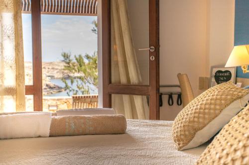 兰佩杜萨瑞丽斯艾素德尔萨德酒店的一间卧室配有一张床,享有海滩美景