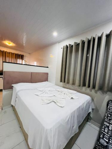 索罗卡巴Casa do Henrique 2的一间卧室配有白色床单