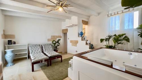 韦列Vico Sauro Appartament的白色的浴室设有浴缸、椅子和窗户