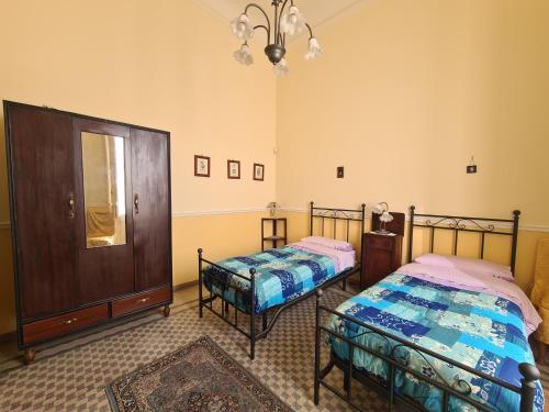米罗Residenza Maria Letizia的一间卧室配有两张床、镜子和吊灯。