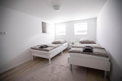 汉诺威80qm - 4 rooms - privat parking - Keller-Basement - MalliBase Apartments的白色墙壁客房的两张床