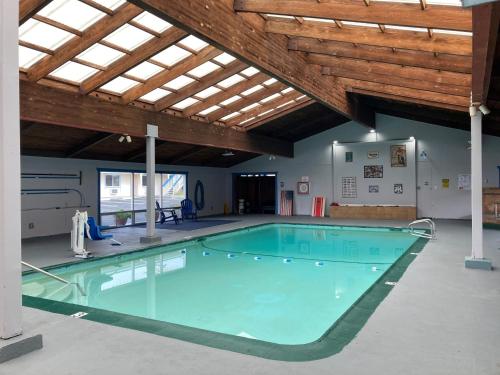 圣西米恩Coast Riders Inn的一座大型游泳池,位于一座拥有木制天花板的建筑中