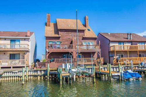 大洋城NEW Bijou Bayside Escape- 3beds, Balcony, Deck, Dock的水边带椅子的码头房屋