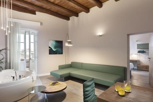 卡利亚里Casa Clat的客厅设有绿色沙发和浴缸