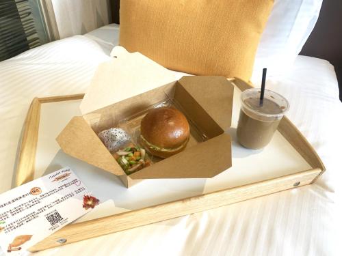台中市璞树文旅的床上的盒子,夹着三明治和饮料