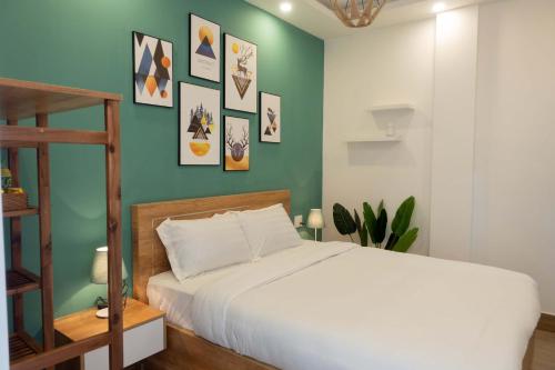 胡志良Dalat Blanc Hotel 2的卧室配有白色的床和绿色的墙壁