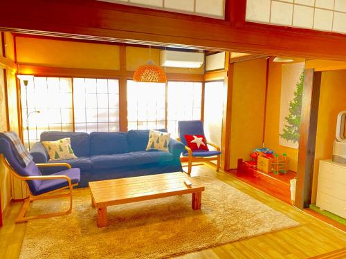 关市Ishimaru House的客厅配有蓝色的沙发和茶几