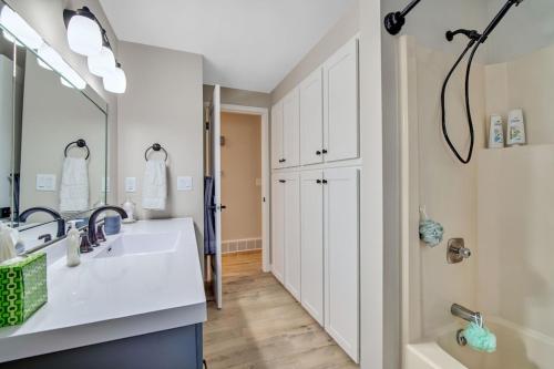 绿湾Green Bay Stay的一间带水槽、浴缸和镜子的浴室