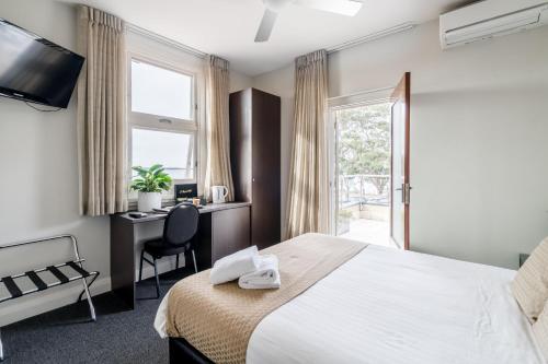 赫斯基森Huskisson Hotel的配有一张床、一张书桌和一扇窗户的酒店客房