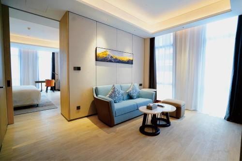 邯郸邯郸丛台温德姆酒店的客厅配有蓝色的沙发和桌子