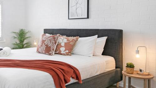 莫斯谷8 on Clarence的卧室内的一张带棕色和白色枕头的床