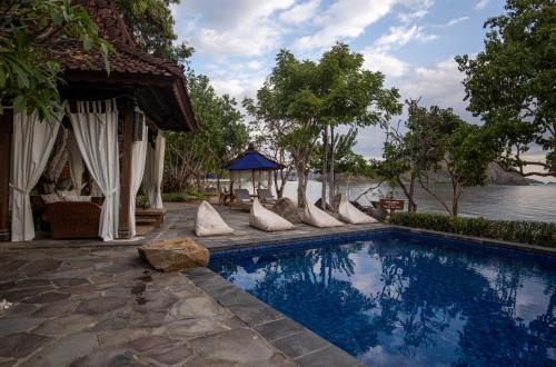 纳闽巴霍Plataran Komodo Resort & Spa - CHSE Certified的旁边设有枕头的游泳池
