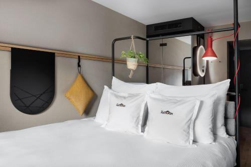 伯尔尼Stay KooooK Bern City - Online Check In的卧室配有白色的床铺和白色的枕头