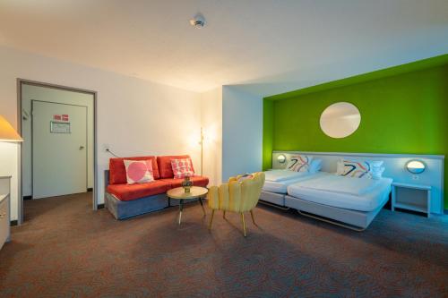 卡塞尔Hessenland Hotel Kassel Innenstadt by Stay Awesome的一间卧室设有一张床和绿色的墙壁