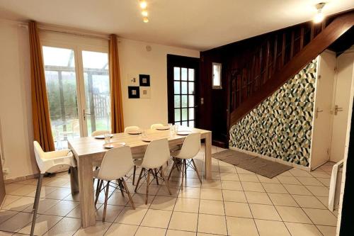 库尔瑟勒·苏尔·梅尔Charming house near the sea的一间带木桌和白色椅子的用餐室