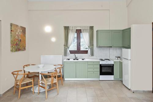 RachesAria Monte Villas的厨房配有绿色橱柜和桌椅
