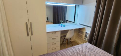 马尼拉Azure urban residences 1BR Unit fits max 3 persons的一间卧室配有书桌、镜子和床