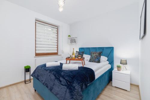 克拉科夫Bunscha Apartment Dębniki Cracow by Renters的一间卧室配有一张蓝色的床,上面有桌子