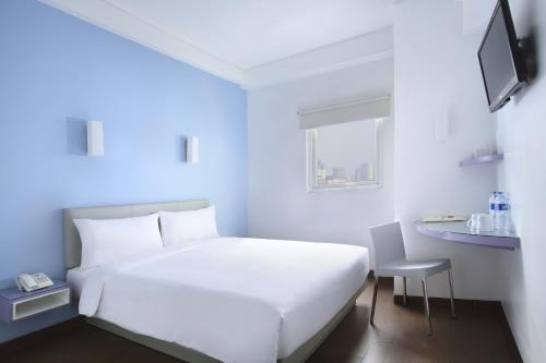 贝克西爱玛黎丝勿加泗巴拉特酒店的一张白色的床,位于带椅子和窗户的房间
