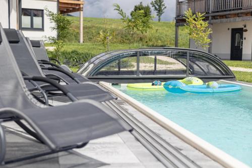 因泽尔Inzell Chalets by ALPS RESORTS的水中一个带椅子和冲浪板的游泳池