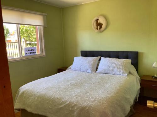 安东尼奥港Terra Patagónica的卧室配有一张带白色床单的大床和窗户。