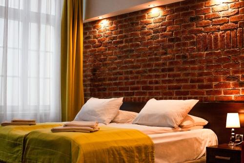 格但斯克Hotel Artus - Old Town的一间卧室设有两张床和砖墙