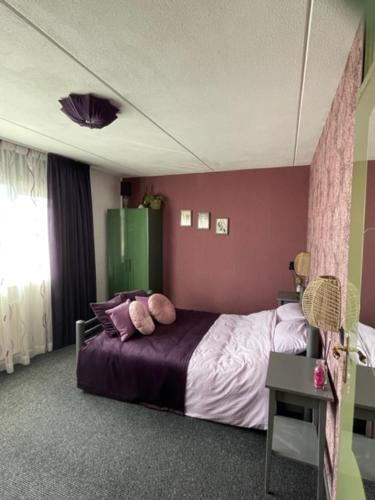 巴伦德雷赫特Bed and breakfast devijfbees的一间卧室配有一张紫色墙壁的床