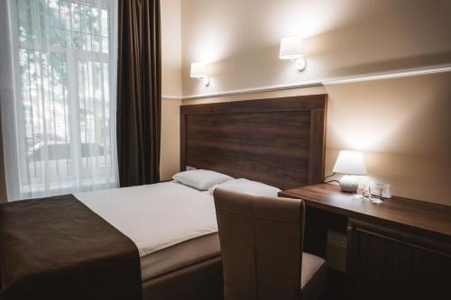 敖德萨Potemkinn Hotel的一间卧室配有一张床、一张书桌和一个窗户。