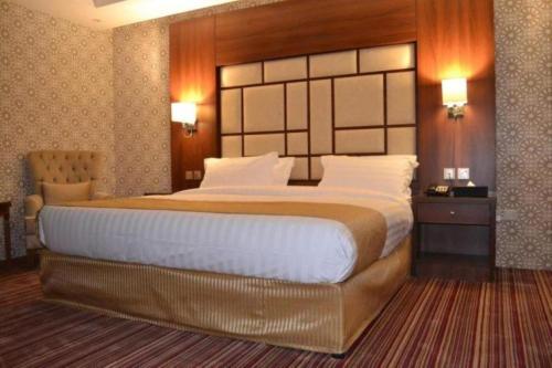 吉达QUIET Jeddah Al Hamra的一间卧室配有一张大床和木制床头板