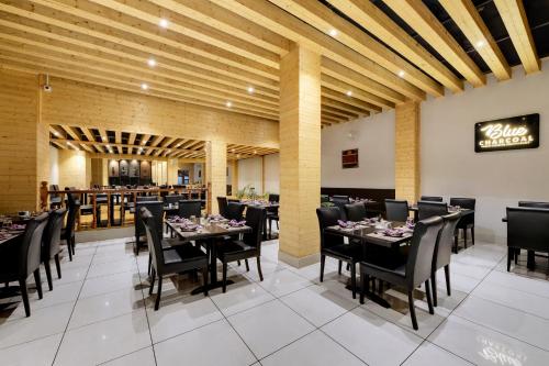 TādongSumi Shangrila Deorali Gangtok的一间带桌椅的用餐室和一间餐厅