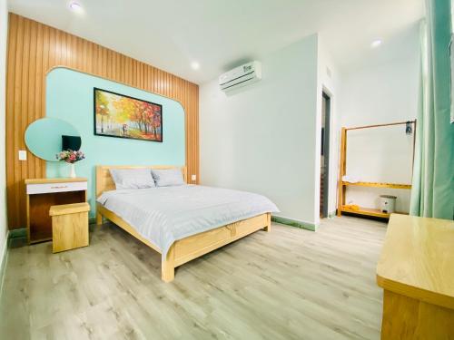 归仁Moon's House Homestay Quy Nhơn的卧室配有一张床,墙上挂有绘画作品