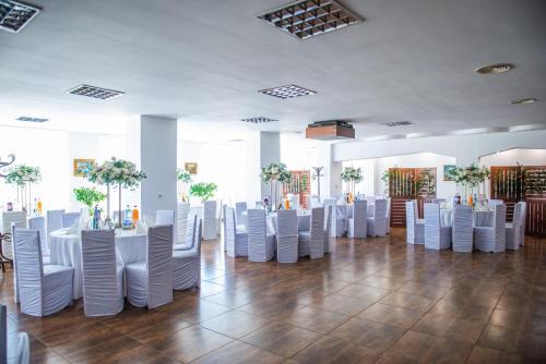 霍雷祖何勒祖酒店的大楼内一间设有白色椅子和桌子的房间