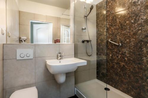 格但斯克穆扎克多姆酒店的一间带水槽、淋浴和卫生间的浴室
