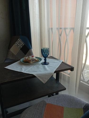 萨克德佐尔镇Alvina complex的一张桌子,上面有一盘食物和一杯